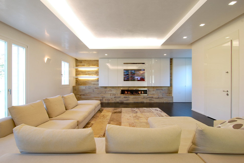 Diseño de salón contemporáneo con paredes blancas, suelo de madera oscura y televisor retractable