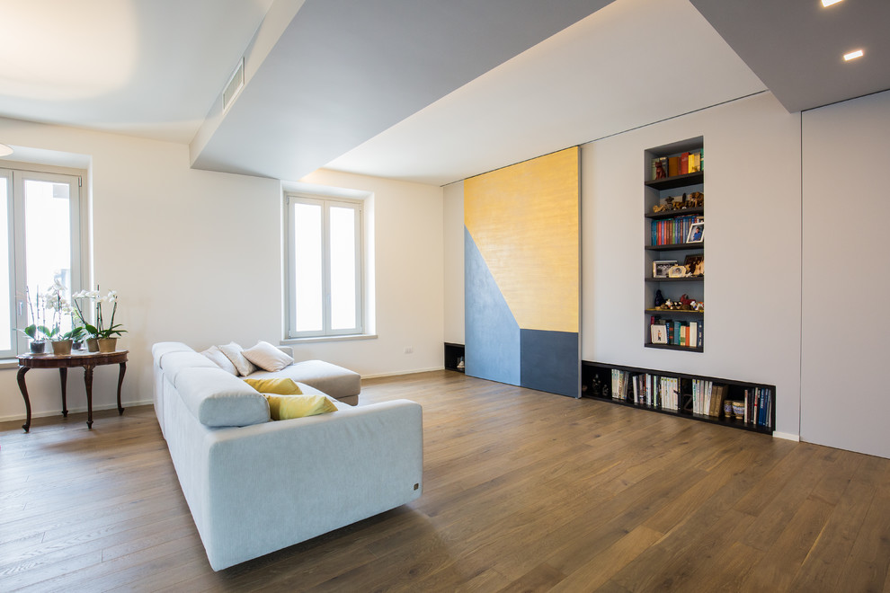 Inspiration pour une salle de séjour design ouverte avec une bibliothèque ou un coin lecture, un mur blanc et un sol en bois brun.