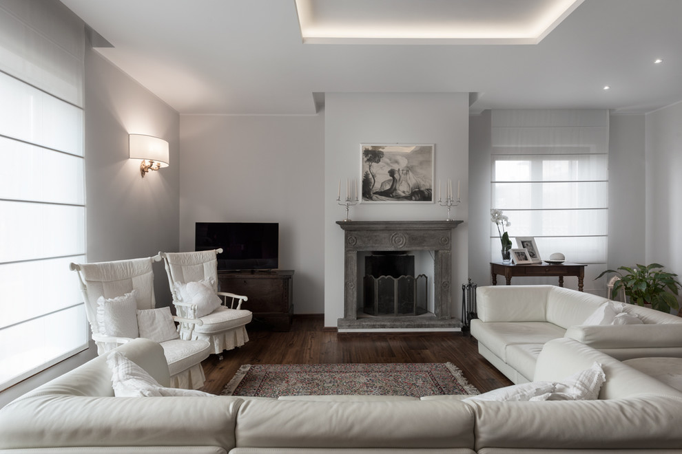Modernes Wohnzimmer mit weißer Wandfarbe, dunklem Holzboden, Kamin und freistehendem TV in Sonstige