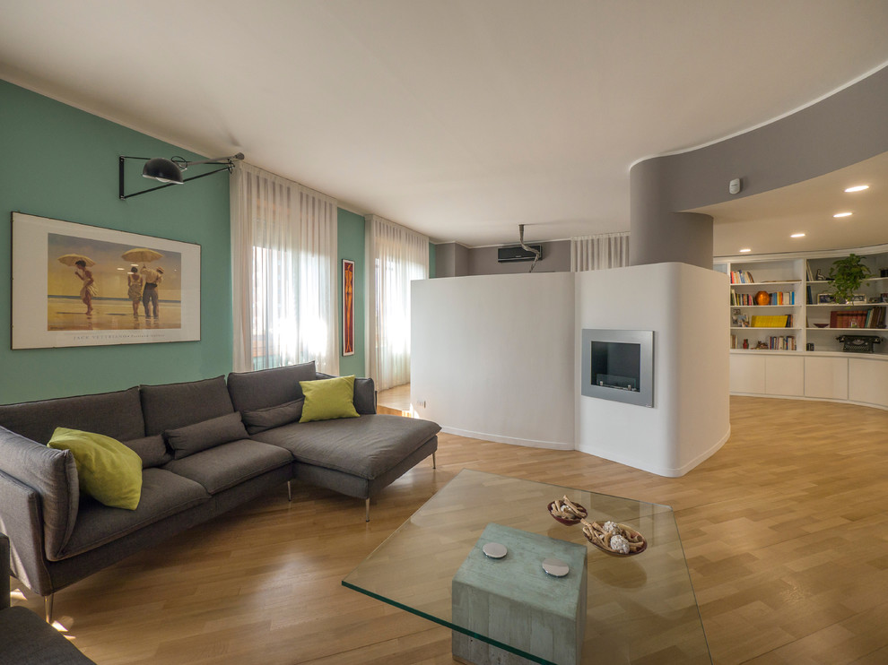 Foto di un grande soggiorno contemporaneo aperto con sala formale, pareti verdi, parquet chiaro e TV autoportante