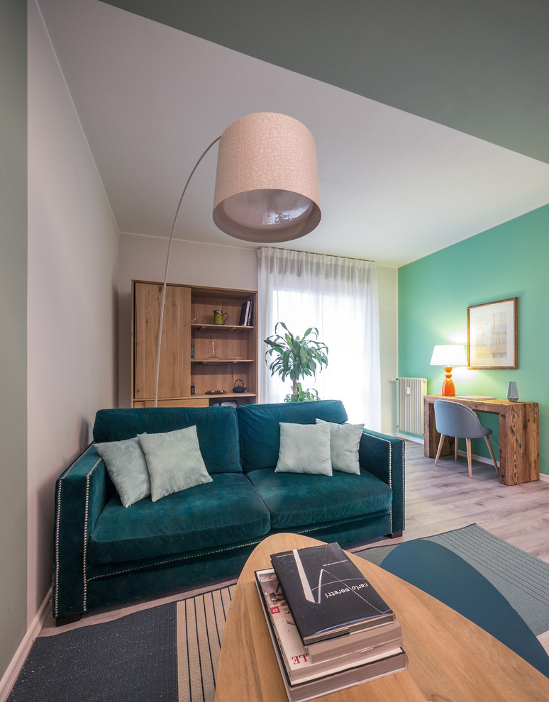 На фото: открытая гостиная комната среднего размера в современном стиле с с книжными шкафами и полками, зелеными стенами, полом из линолеума, мультимедийным центром и серым полом