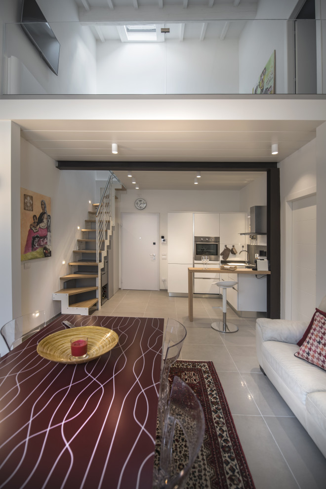 Mittelgroßes, Offenes Modernes Wohnzimmer mit weißer Wandfarbe, Porzellan-Bodenfliesen, TV-Wand, grauem Boden und Holzdecke in Florenz