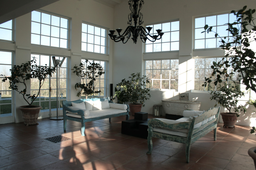 Immagine di un grande soggiorno tradizionale aperto con pavimento in terracotta e pareti bianche