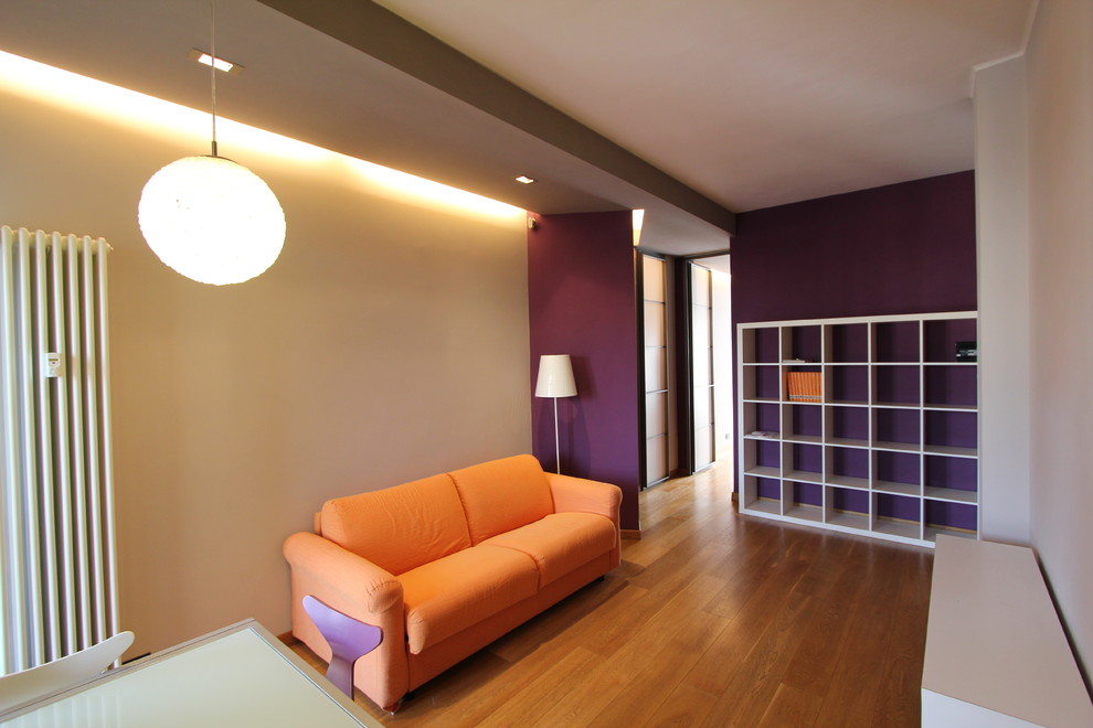 Photo of a medium sized contemporary open plan games room in Turin with a reading nook, purple walls, medium hardwood flooring, a wall mounted tv and beige floors.