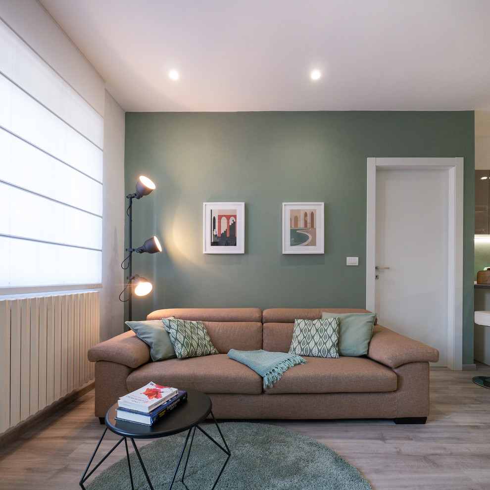 Ejemplo de salón abierto contemporáneo pequeño con paredes verdes, suelo de linóleo, chimenea de esquina, marco de chimenea de yeso y pared multimedia