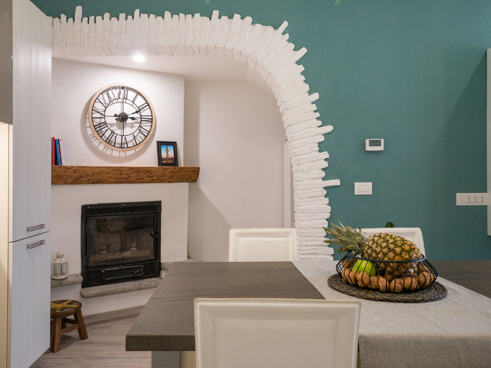 Réalisation d'un petit salon design ouvert avec un mur vert, un sol en linoléum, une cheminée d'angle, un manteau de cheminée en plâtre et un téléviseur encastré.