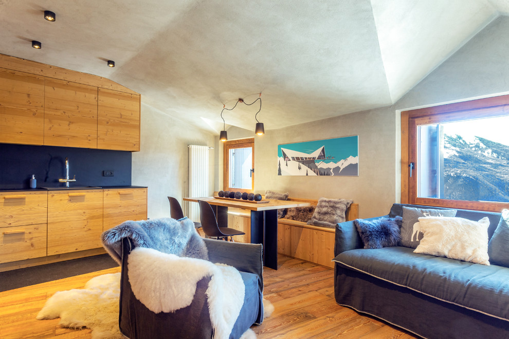 Exemple d'un salon montagne ouvert avec un sol en bois brun et un mur gris.
