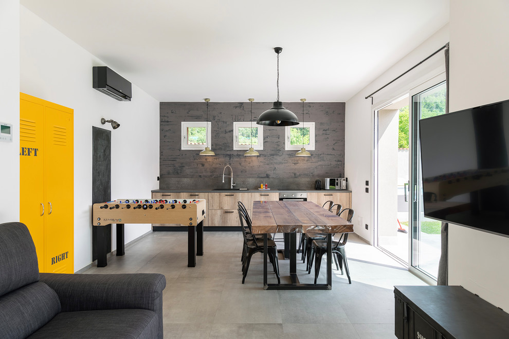 Game room - industrial concrete floor and gray floor game room idea in Milan with white walls, no fireplace and a wall-mounted tv