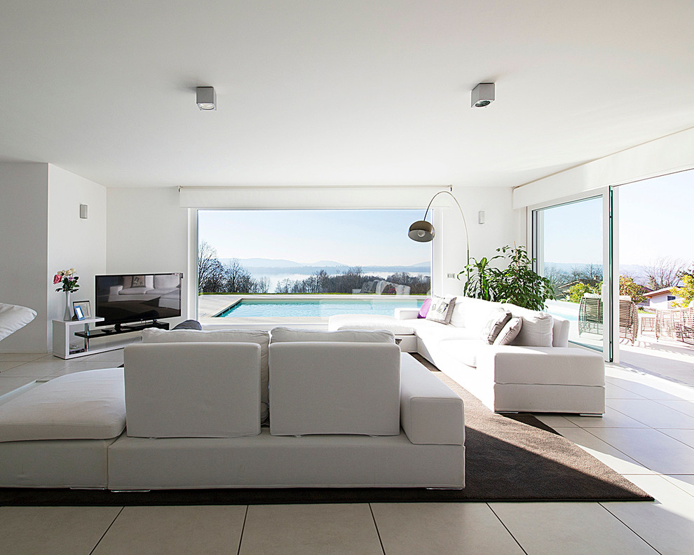 Ejemplo de salón para visitas abierto contemporáneo extra grande con paredes blancas y televisor independiente
