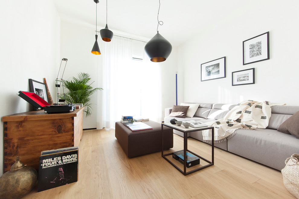 Modernes Wohnzimmer mit weißer Wandfarbe und hellem Holzboden in Venedig