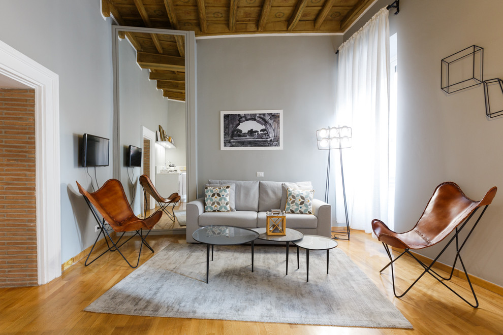 Idee per un soggiorno mediterraneo di medie dimensioni con pareti grigie, parquet chiaro e TV a parete