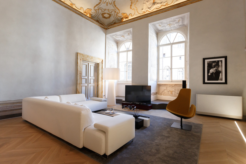 Aménagement d'une salle de séjour contemporaine avec parquet clair et un téléviseur indépendant.