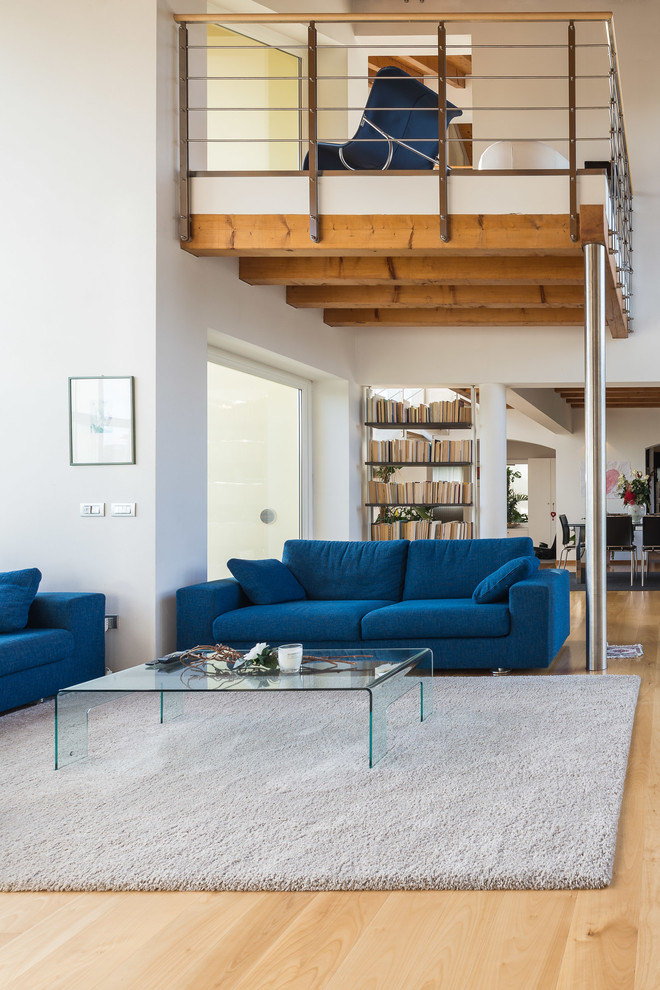 Diseño de sala de estar abierta moderna grande con paredes blancas y suelo de madera clara
