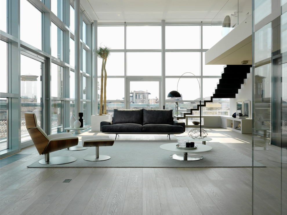 Design ideas for an expansive contemporary formal living room in Milan with white walls and light hardwood flooring.