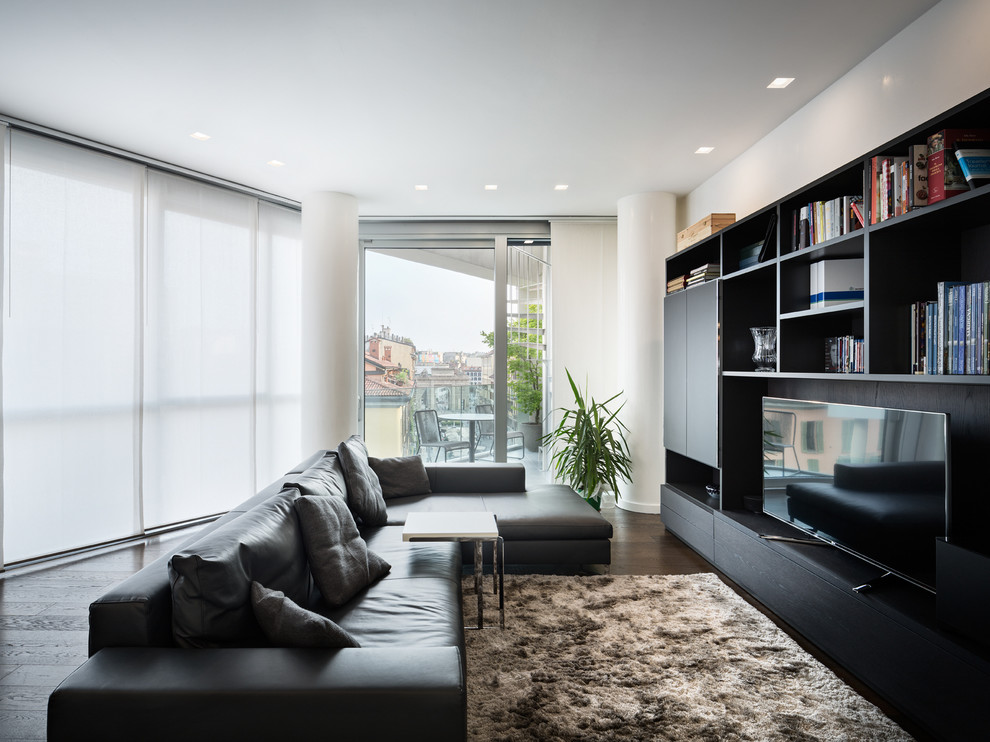 Cette image montre une grande salle de séjour design avec un mur blanc, parquet foncé et un téléviseur indépendant.