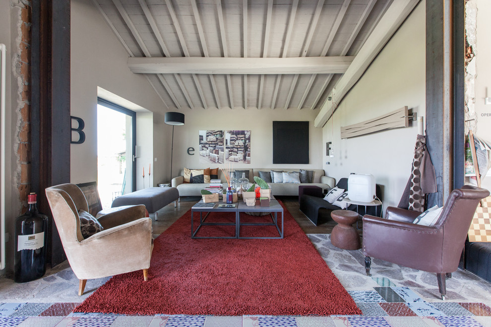 Imagen de sala de estar abierta actual grande sin televisor con paredes beige y suelo multicolor