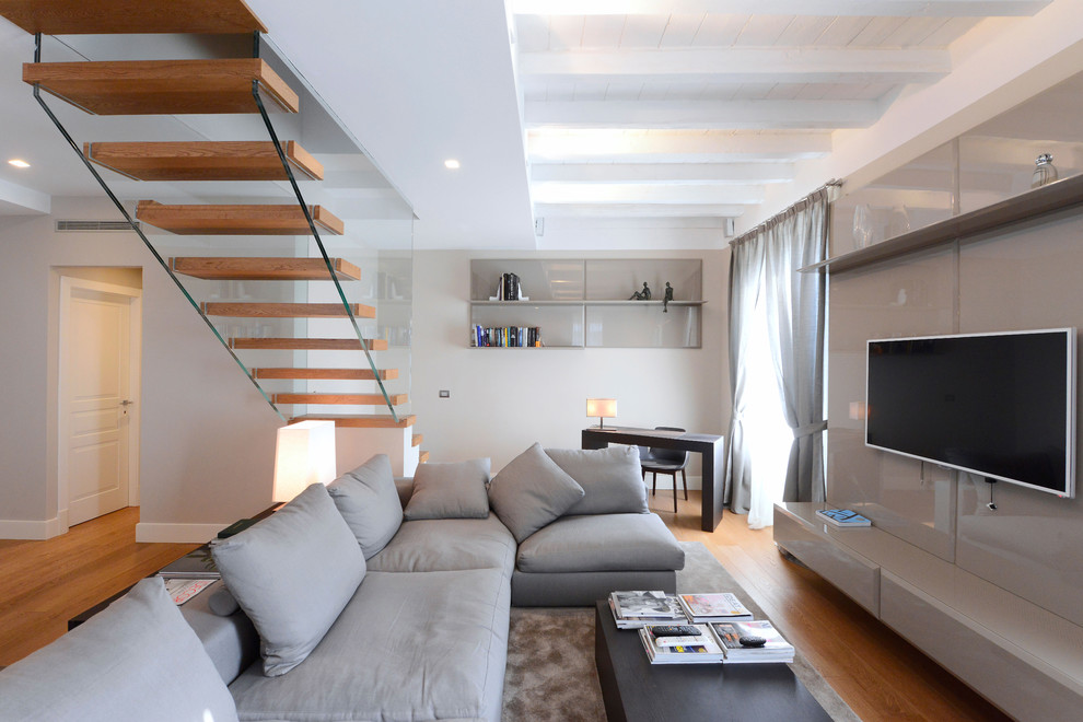 Ispirazione per un soggiorno minimalista di medie dimensioni e aperto con pareti bianche, pavimento in legno massello medio e TV a parete