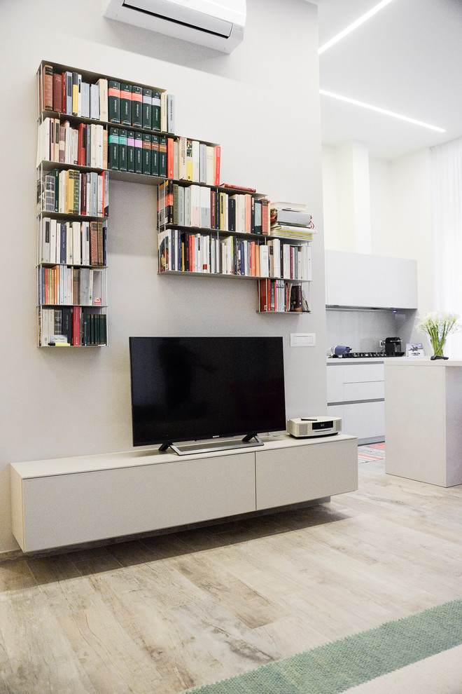 Inspiration för moderna loftrum, med ett bibliotek, vita väggar, målat trägolv, en fristående TV och brunt golv