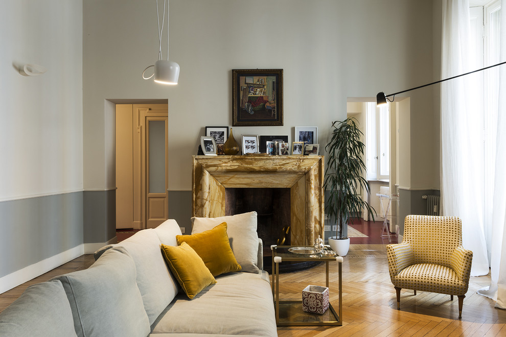 Diseño de sala de estar cerrada contemporánea grande con suelo de madera en tonos medios, todas las chimeneas y marco de chimenea de piedra