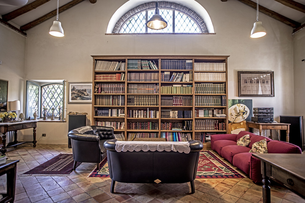 Cette photo montre une salle de séjour nature avec une bibliothèque ou un coin lecture, un mur beige et tomettes au sol.