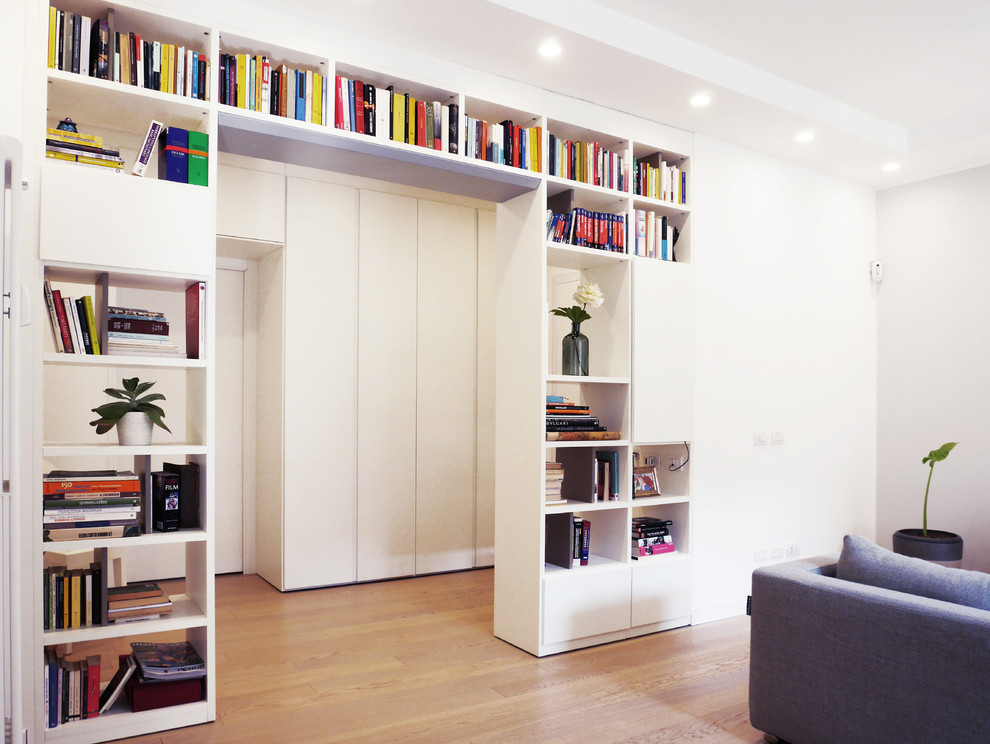 Idee per un soggiorno minimalista di medie dimensioni e aperto con libreria, pareti bianche, pavimento in gres porcellanato, TV a parete e pavimento beige