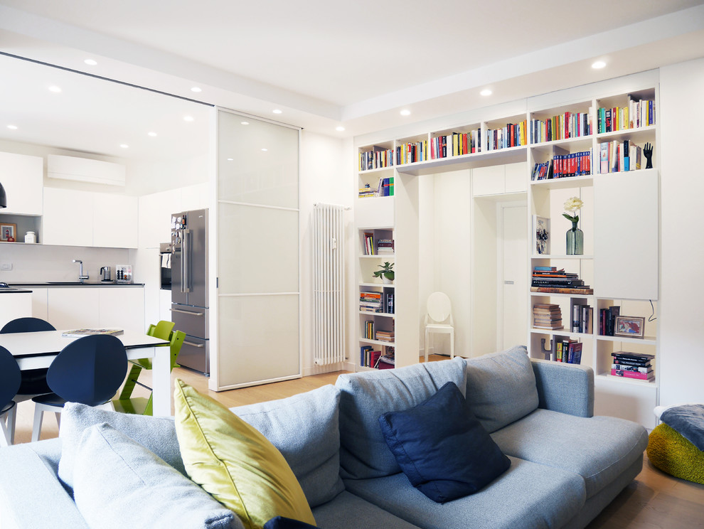 Esempio di un soggiorno moderno di medie dimensioni e aperto con libreria, pareti bianche, pavimento in gres porcellanato, TV a parete e pavimento beige
