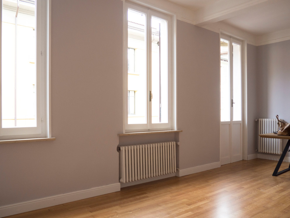 Immagine di un soggiorno minimalista di medie dimensioni e chiuso con pareti grigie, pavimento in legno verniciato e pavimento beige