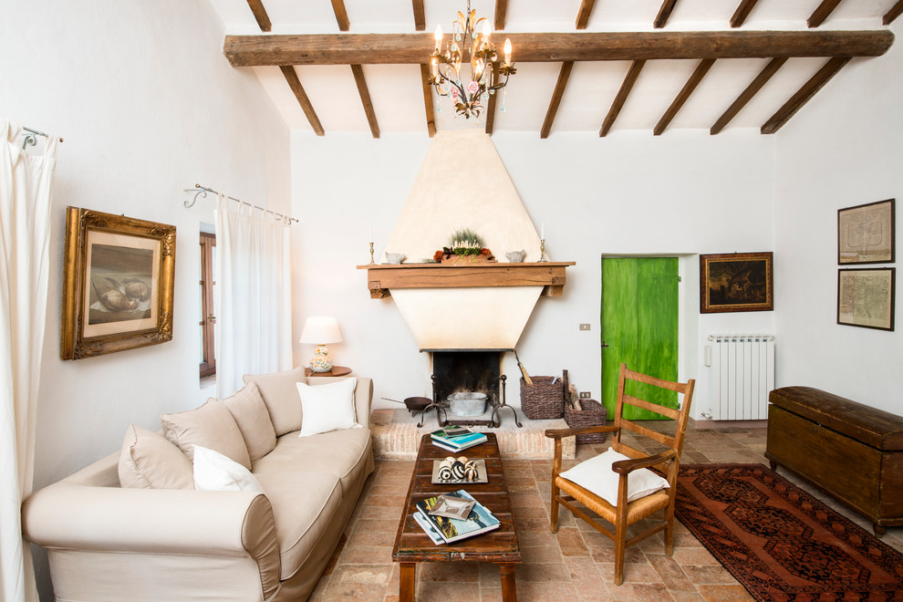 Immagine di un piccolo soggiorno country con pareti bianche, camino classico, nessuna TV e pavimento marrone