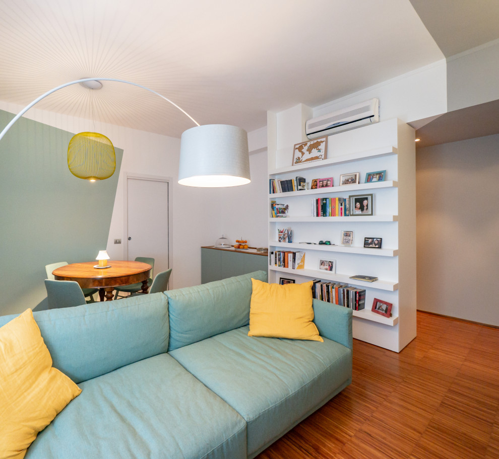 Imagen de biblioteca en casa abierta contemporánea con paredes multicolor, suelo de madera oscura y pared multimedia