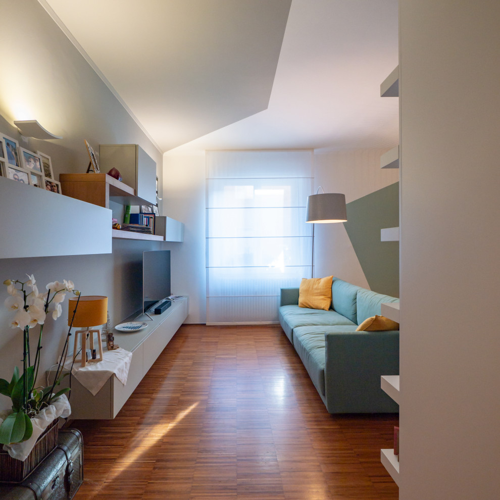 Example of a trendy open concept dark wood floor living room library design in Milan with multicolored walls and a media wall