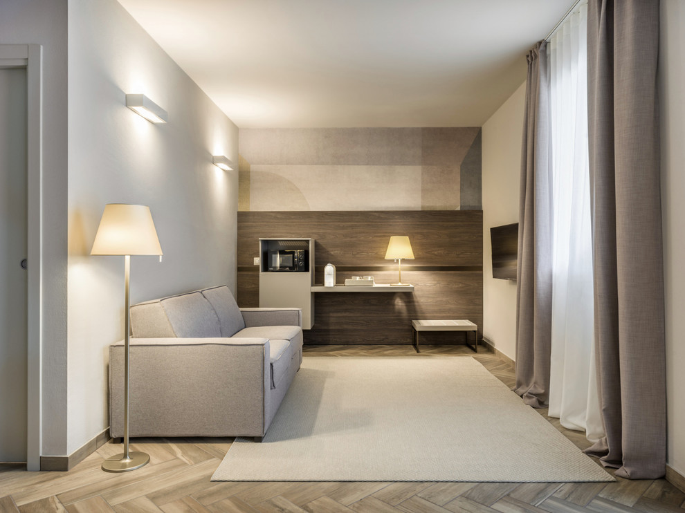 Immagine di un soggiorno minimal di medie dimensioni e aperto con pareti beige, pavimento in gres porcellanato, nessun camino, TV a parete e pavimento marrone