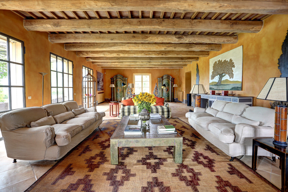 Стильный дизайн: гостиная комната в средиземноморском стиле с оранжевыми стенами и бежевым полом - последний тренд