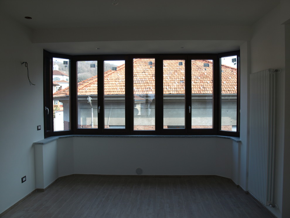 Immagine di un soggiorno design di medie dimensioni e aperto con pareti beige, pavimento in gres porcellanato, parete attrezzata e pavimento beige