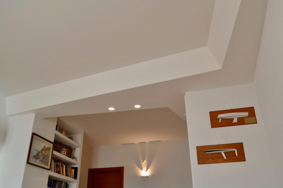 Foto de biblioteca en casa abierta contemporánea de tamaño medio con paredes blancas y suelo de madera clara