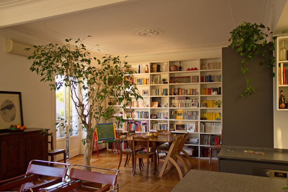 Mittelgroße, Offene Moderne Bibliothek mit weißer Wandfarbe und hellem Holzboden in Mailand