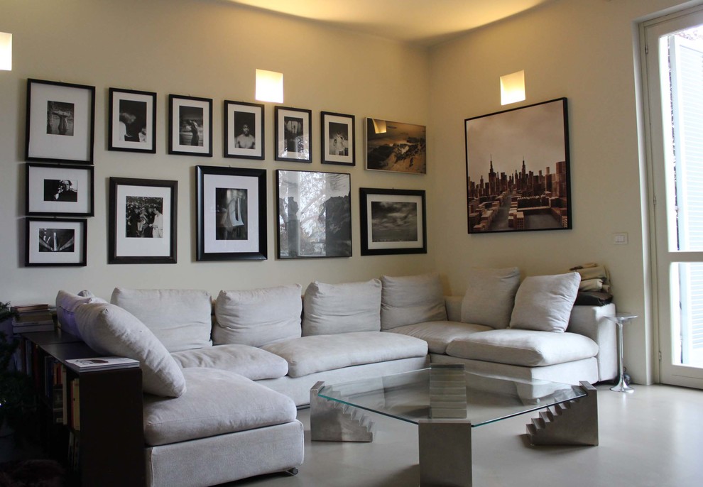 Idee per un ampio soggiorno minimal aperto con sala formale, pareti beige, pavimento in cemento e TV a parete