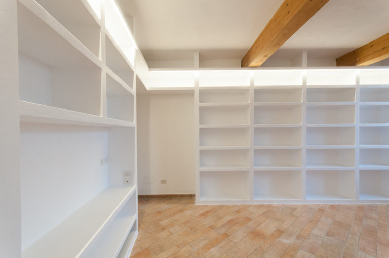 Esempio di un grande soggiorno contemporaneo chiuso con libreria, pareti bianche e parete attrezzata