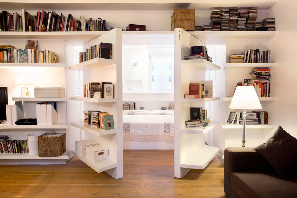 Идея дизайна: изолированная гостиная комната в современном стиле с с книжными шкафами и полками, белыми стенами, светлым паркетным полом и коричневым диваном