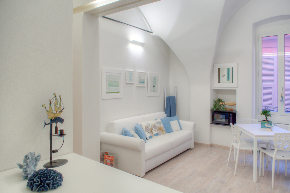 Ispirazione per un soggiorno mediterraneo aperto con pareti bianche, pavimento in laminato e TV a parete