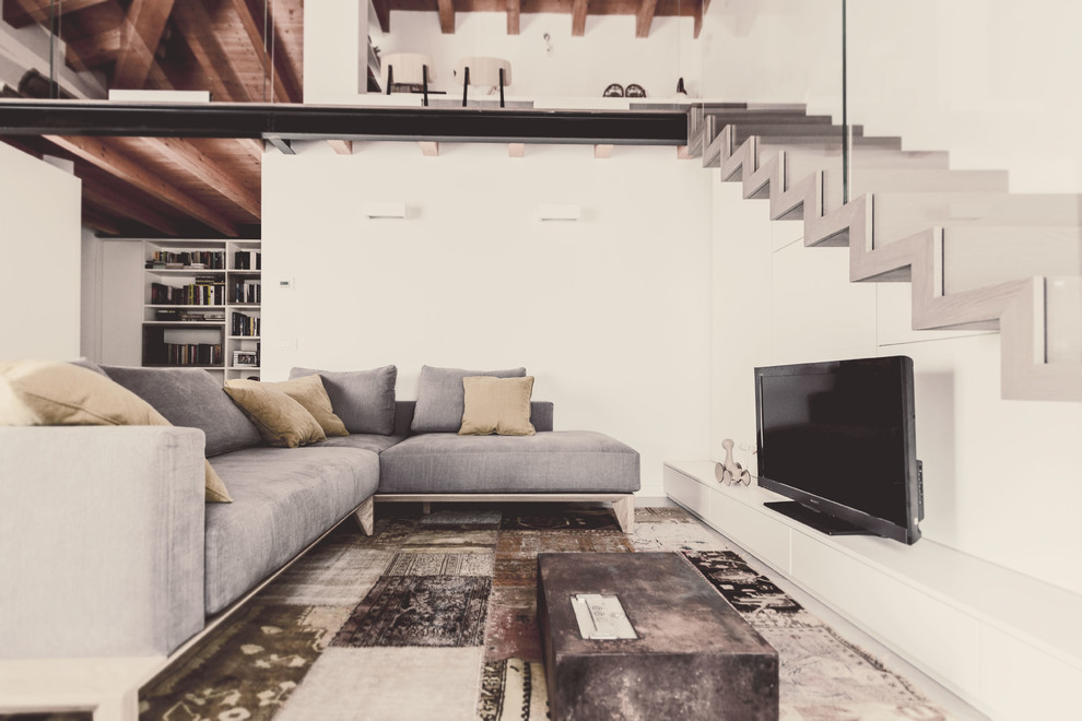 Kleines, Offenes Modernes Wohnzimmer mit weißer Wandfarbe, Porzellan-Bodenfliesen, Gaskamin, freistehendem TV und grauem Boden in Mailand