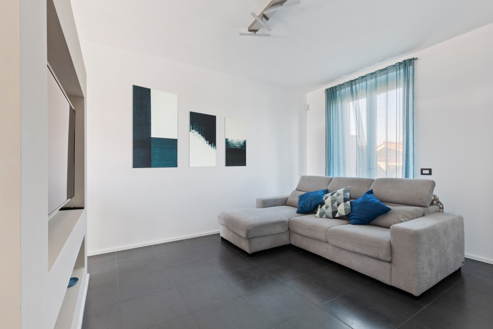Immagine di un soggiorno design di medie dimensioni e aperto con pareti bianche, pavimento in gres porcellanato, parete attrezzata e pavimento nero