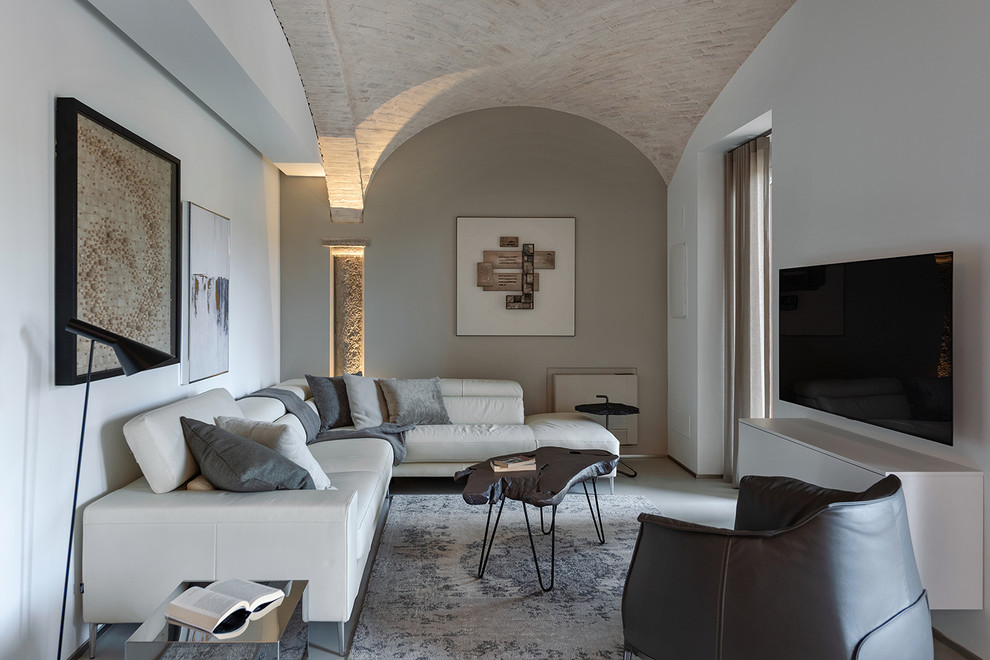 Esempio di un soggiorno mediterraneo con pareti grigie, TV a parete, pavimento grigio e tappeto