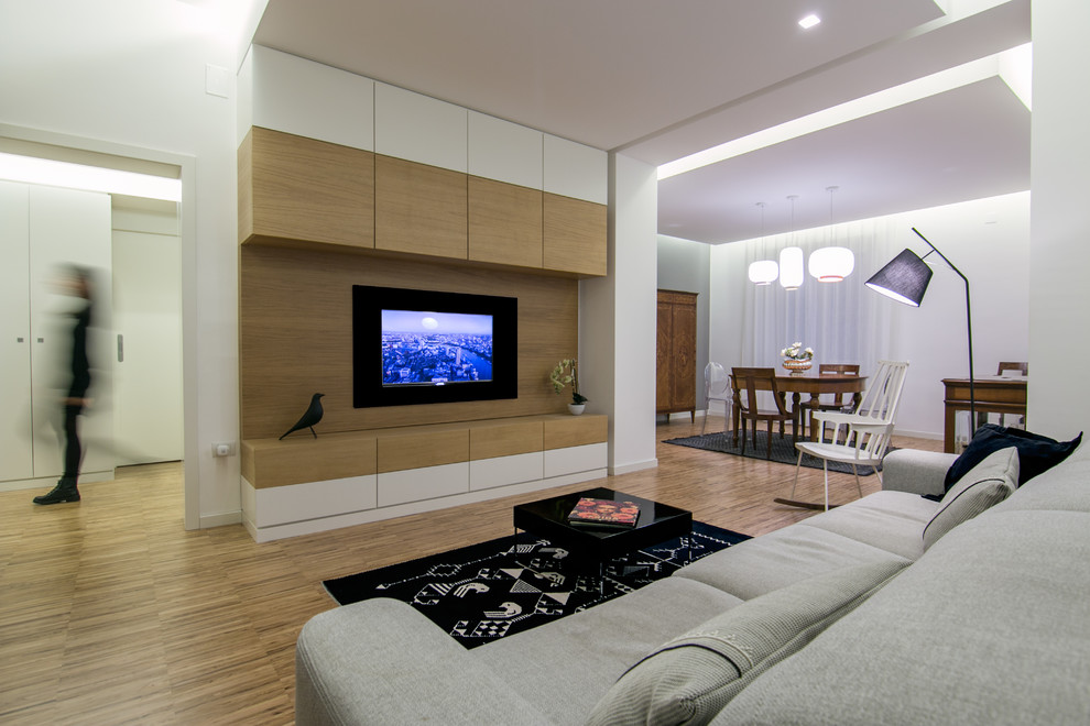 Стильный дизайн: открытая гостиная комната среднего размера в современном стиле с серыми стенами, паркетным полом среднего тона и мультимедийным центром - последний тренд