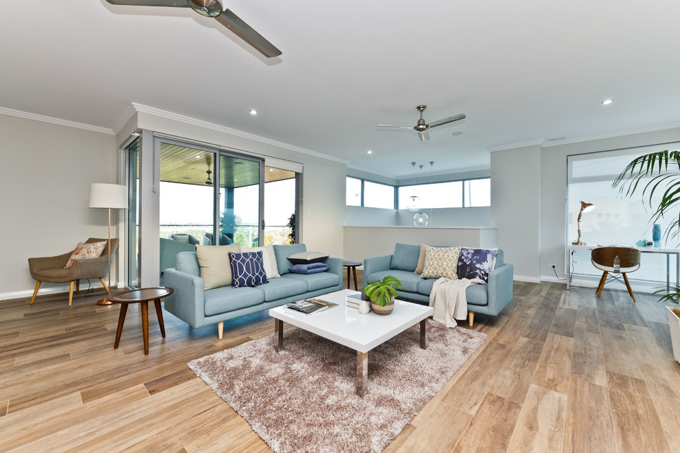 Foto de sala de estar abierta costera con paredes grises y suelo de madera clara