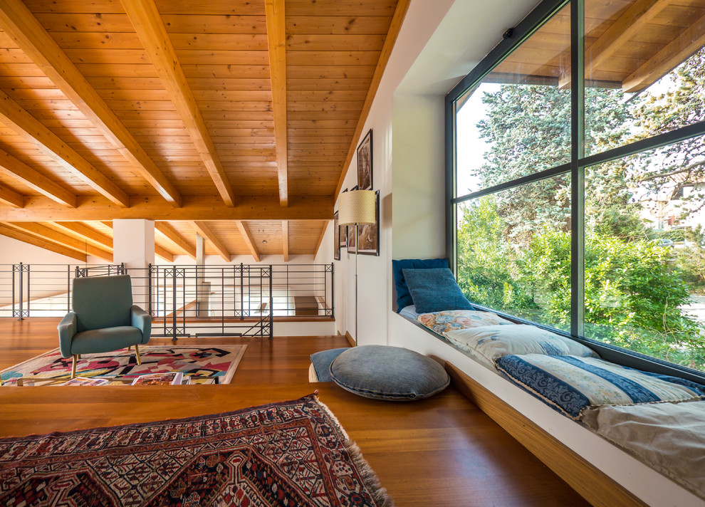 Ejemplo de sala de estar tipo loft rural sin chimenea con paredes blancas y suelo de madera en tonos medios
