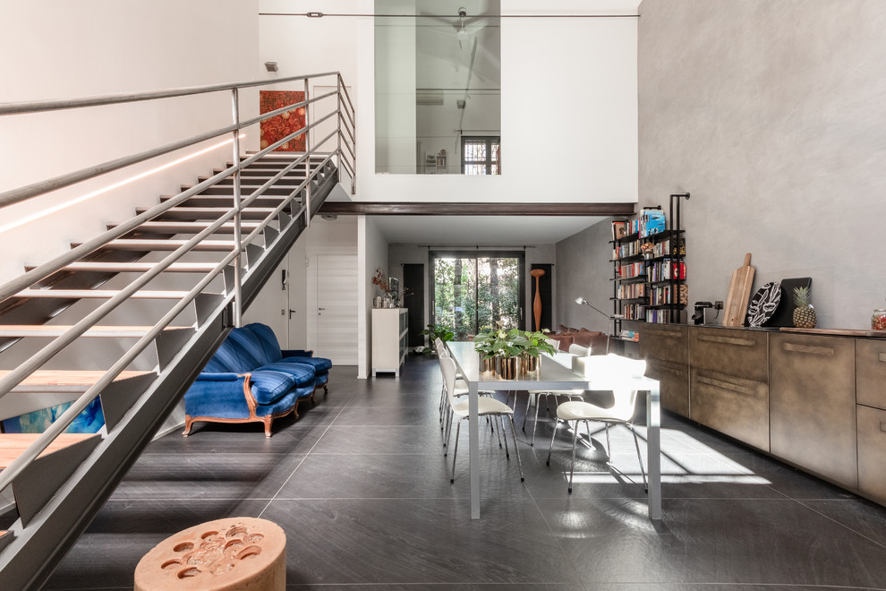 Idee per un grande soggiorno industriale stile loft con libreria, pareti multicolore, pavimento in gres porcellanato e pavimento nero