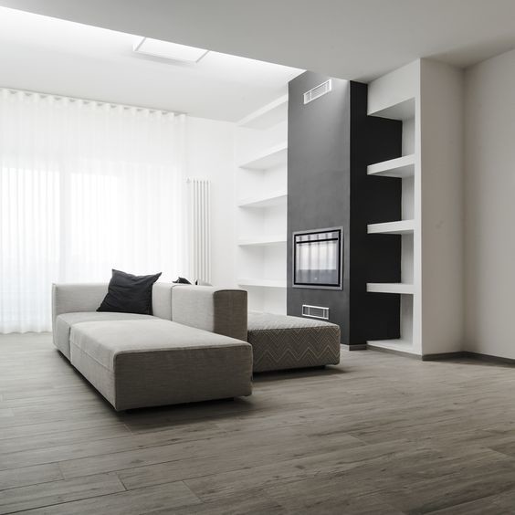 Immagine di un soggiorno minimalista di medie dimensioni e stile loft con pareti bianche, pavimento in gres porcellanato, stufa a legna, cornice del camino in intonaco e TV autoportante