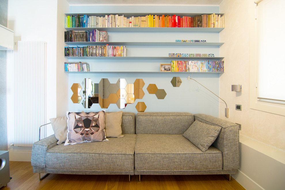 Idee per un piccolo soggiorno eclettico con libreria, pareti multicolore, parquet chiaro e TV a parete