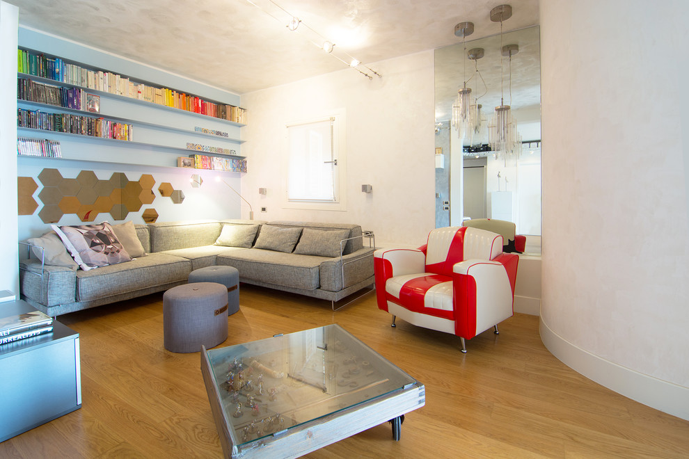 Стильный дизайн: гостиная комната среднего размера в стиле фьюжн с с книжными шкафами и полками, разноцветными стенами, светлым паркетным полом и телевизором на стене - последний тренд