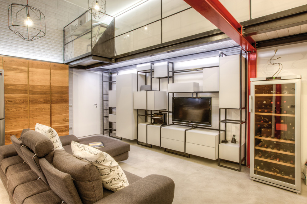 Cette photo montre une salle de séjour mansardée ou avec mezzanine industrielle avec un mur blanc, sol en béton ciré, un téléviseur indépendant et un sol gris.